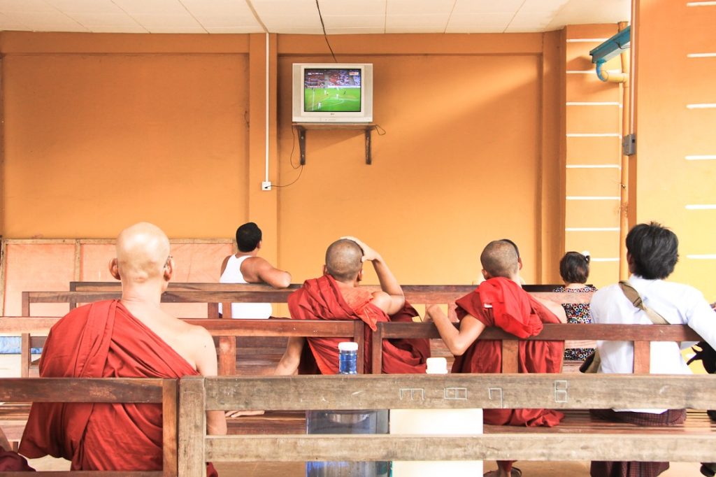 en attendant le camion qui nous mènera au Rocher d'or en Birmanie, les moines regardent le foot dans la salle d'attente