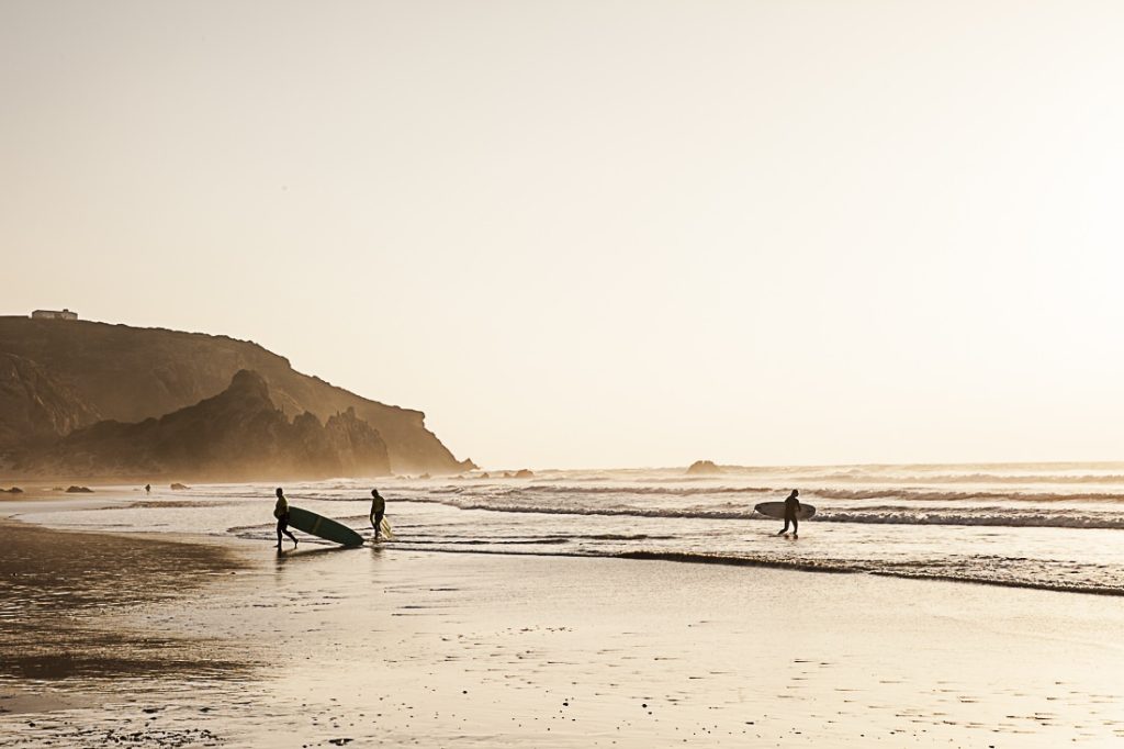 Au coucher du soleil sur la page do Amado a carrapateira, les surfers s'en donnent à coeur joie