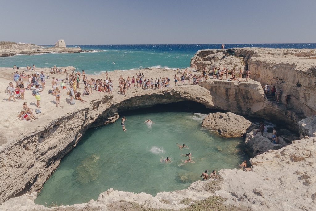 trou d'eau entouré de roche dans lequel les gens plongent dans les Pouilles
