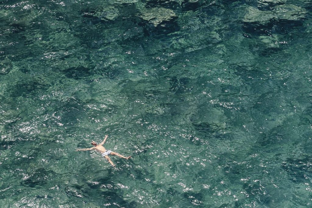 Personne flottant en étoile dans les eaux cristallines de la mer Adriatique à Polignano a Mare