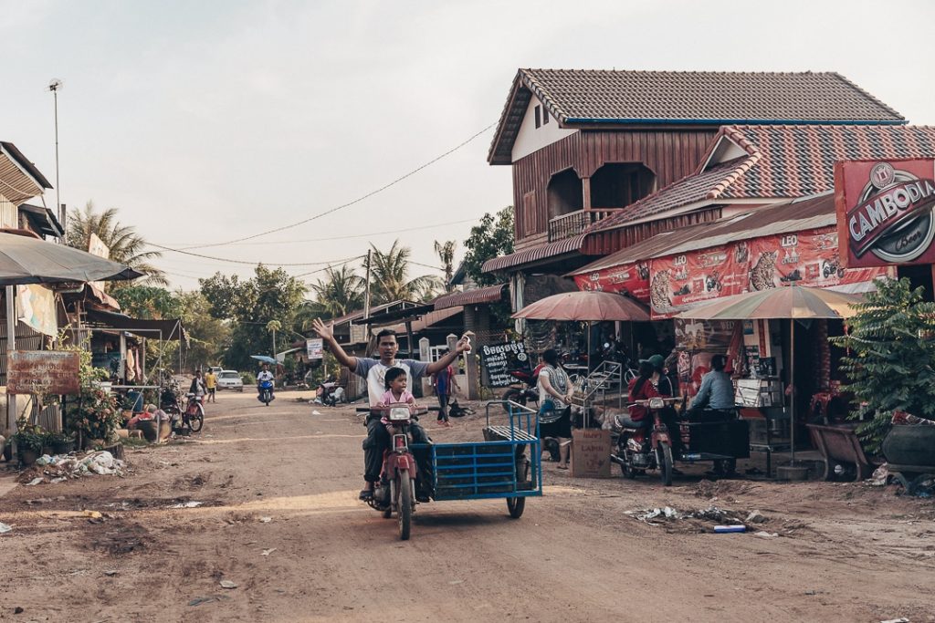 Moto dans une rue en terre battue de Banteay Chhmar