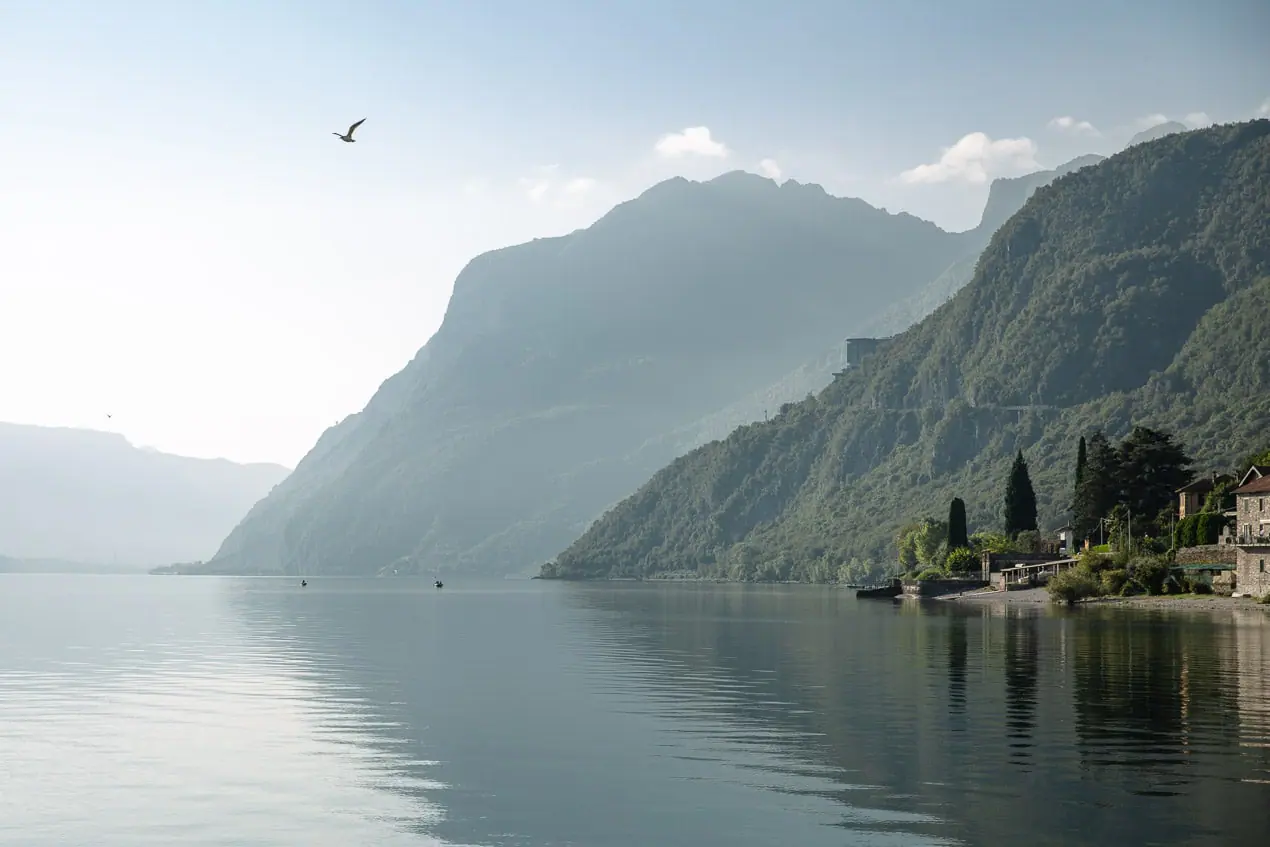 vue brumeuse sur le lac de côme avec les collines se reflétant dans l'eau