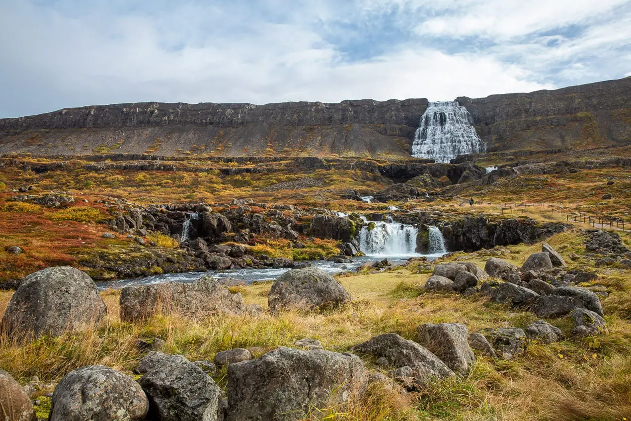 cascade descendant des montagnes vers le fjord en Islande