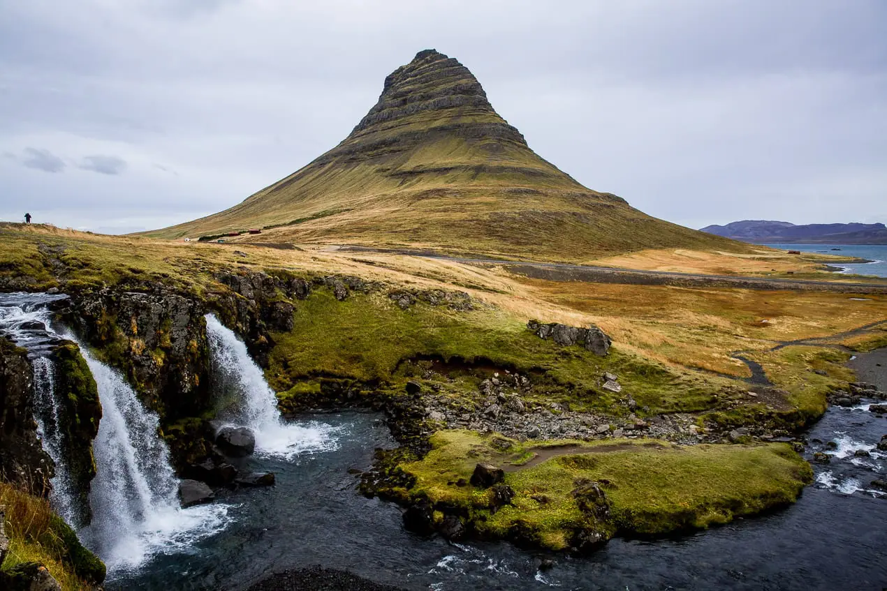 une cascade en Islande avec un volcan en arrière plan