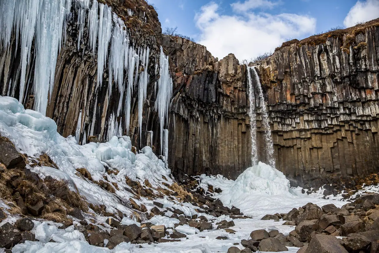 cascade dans un décor de colonnes basaltiques en Islande