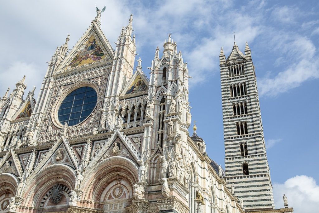 Façade en marbre blanc, vert et rose de la cathédrale de Sienne, chef-d’œuvre de l’art gothique italien richement décorée de sculptures