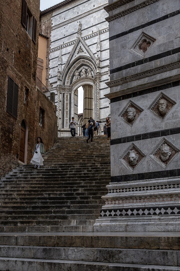 Portail sculpté de la cathédrale de Sienne avec ses colonnes torsadées, ses statues détaillées et son marbre polychrome