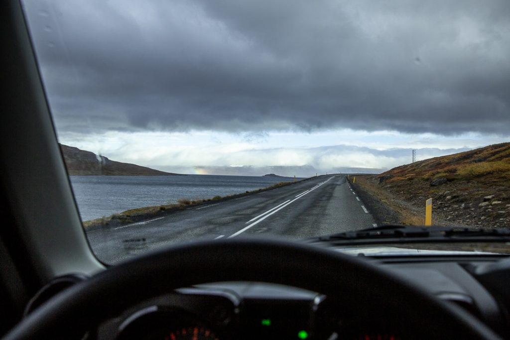 Vue panoramique depuis l'intérieur d'une voiture sur un fjord au nord-ouest de l'Islande sous un paysage tempêtueux