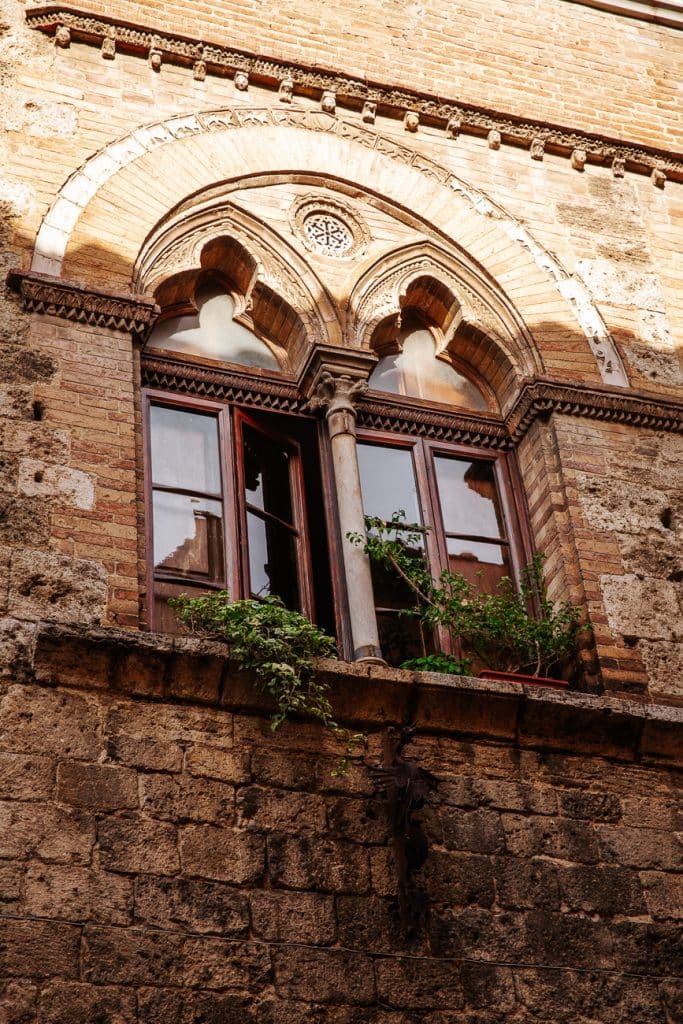 fenêtre gothique végétalisée dans la cité perchée de San Gimignano