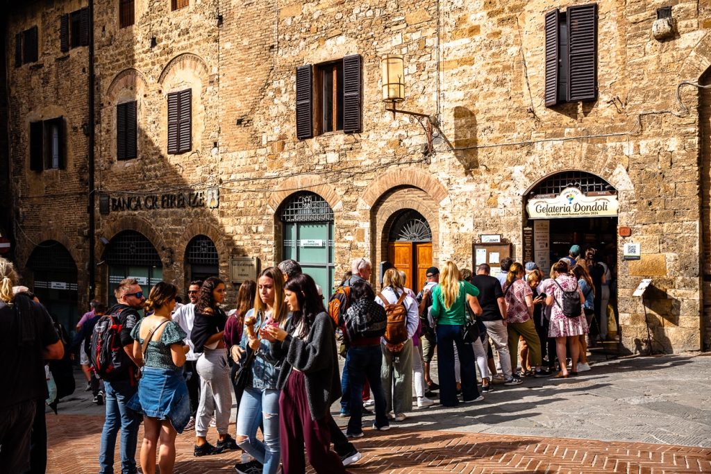Foule de personnes faisant la queue pour acheter une glace à la Gelateria Dondoli de San Gimignano élue meilleur glacier au monde en 2024.