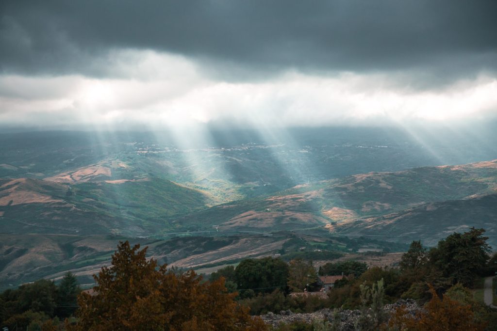 Rayons de soleil passant à travers les nuages noirs dans les campagnes toscanes