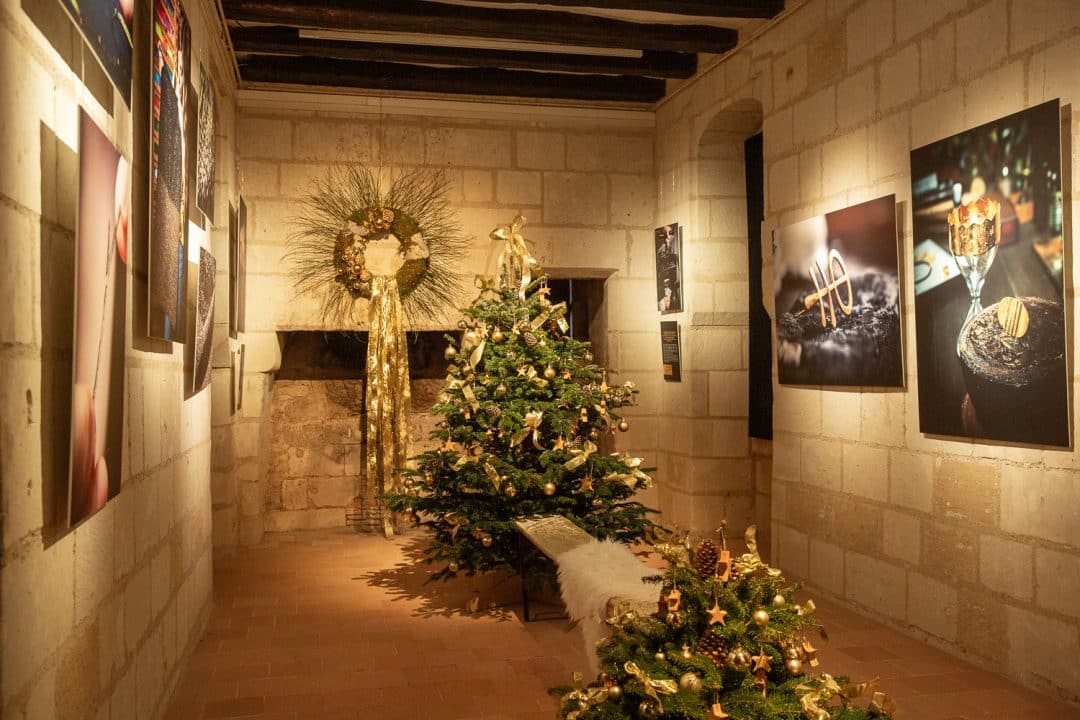 sapins de noël dans une salle de la forteresse Chinon où sont exposées des photos sur les métiers d'art