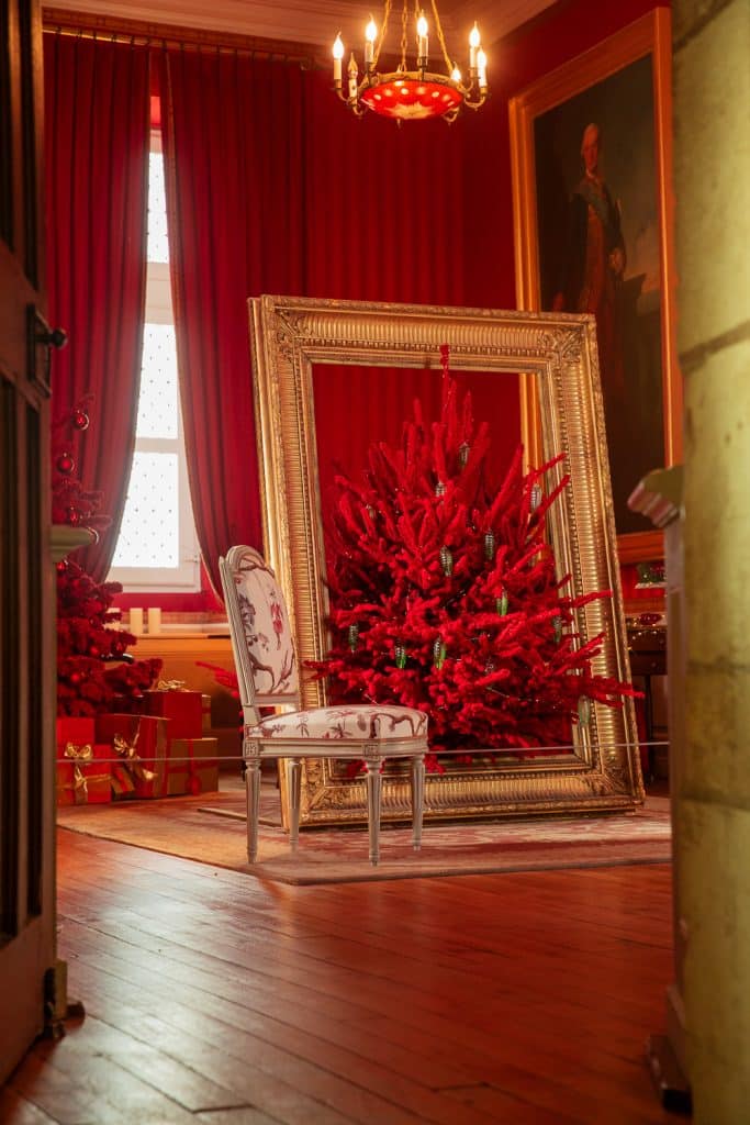 sapin de noel rouge installé dans un cadre doré