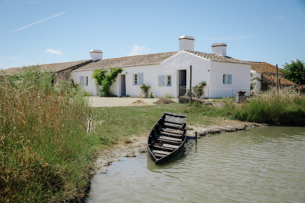 Barque au bord de l'eau devant une maison vendéenne au Daviaud